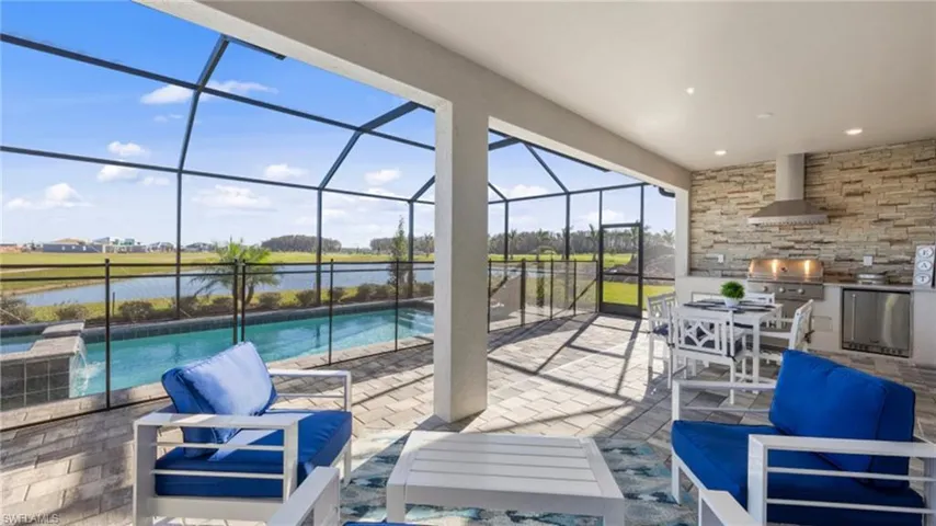 View of patio with an outdoor pool, a lanai, a water view, area for grilling, and outdoor lounge area