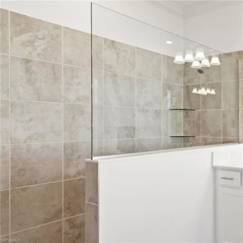 Full bath with vanity, crown molding, and a walk in shower