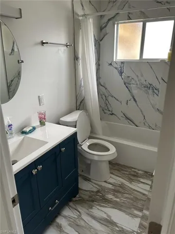 Prior to Milton.  Full bathroom featuring vanity, shower / tub combo with curtain, and toilet