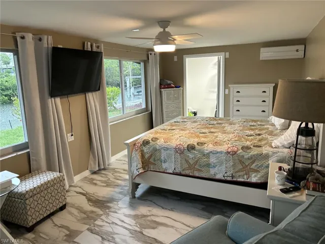 Prior to Milton.  Master bedroom featuring a wall mounted AC and ceiling fan.  Doorway to walk in closet.