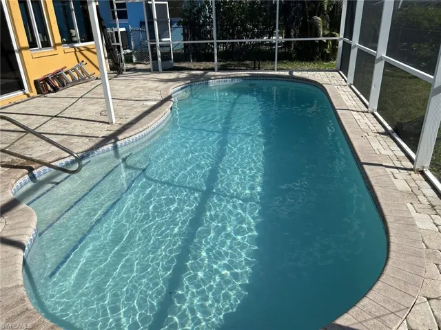 View of swimming pool with a patio area and a lanai