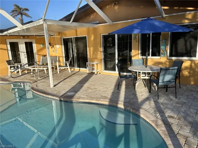 View of swimming pool featuring a patio and a lanai