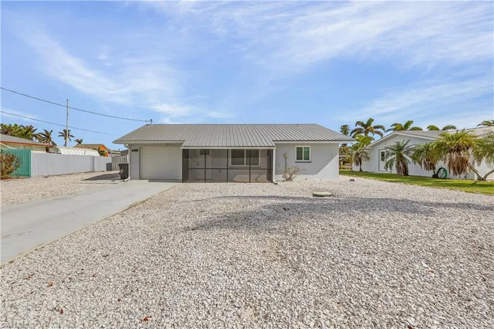 View of front of property featuring a garage and a sunroom