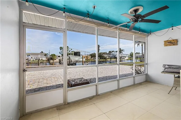 Unfurnished sunroom featuring a water view, ceiling fan, and a healthy amount of sunlight