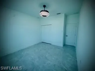 Unfurnished bedroom with a closet and concrete floors