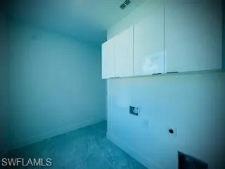Laundry room with electric dryer hookup and cabinet space