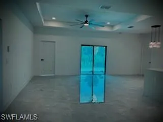 Empty room with a tray ceiling and ceiling fan