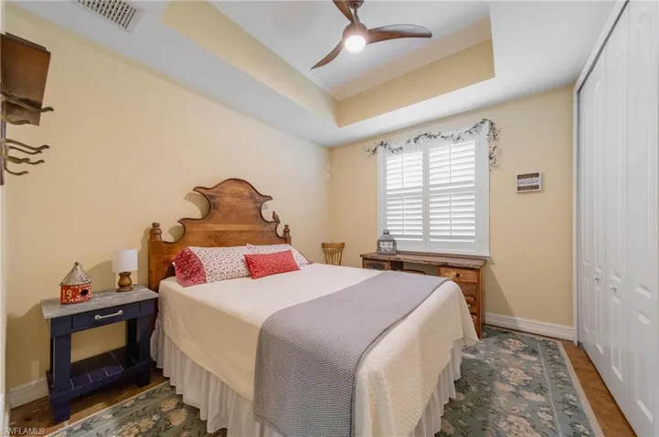 Bedroom with dark hardwood / wood-style flooring, ceiling fan, a closet, and ornamental molding