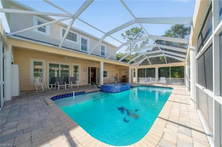 View of swimming pool featuring a lanai, an in ground hot tub, ceiling fan, and a patio