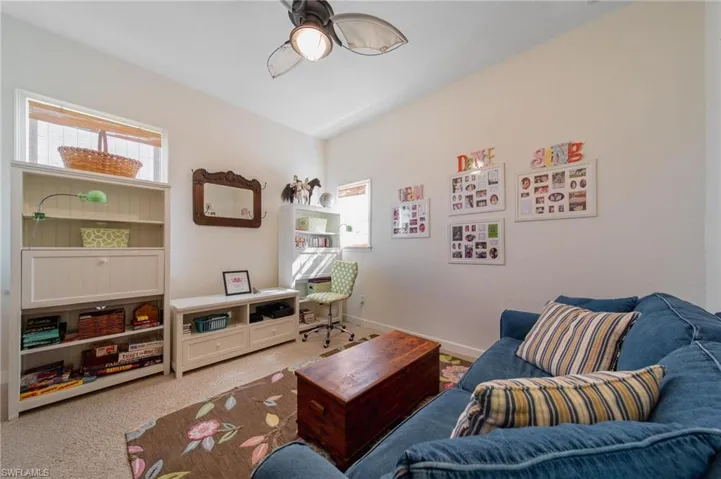 Living area with ceiling fan and carpet