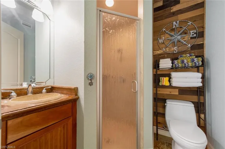 Bathroom with toilet, vanity, and walk in shower