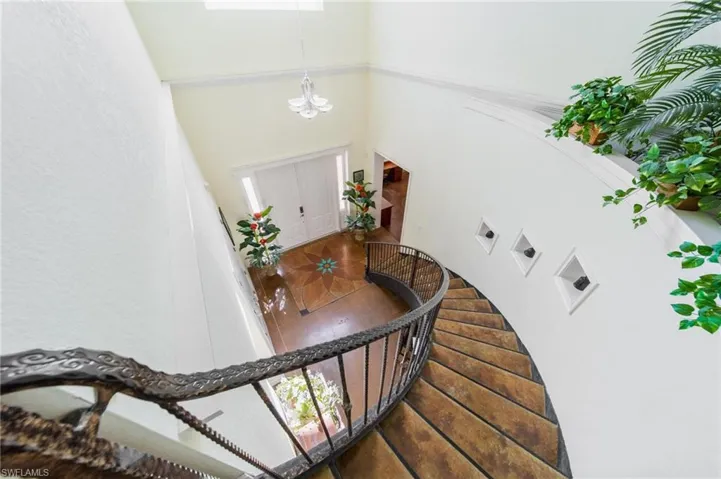 Stairway featuring a high ceiling and a notable chandelier