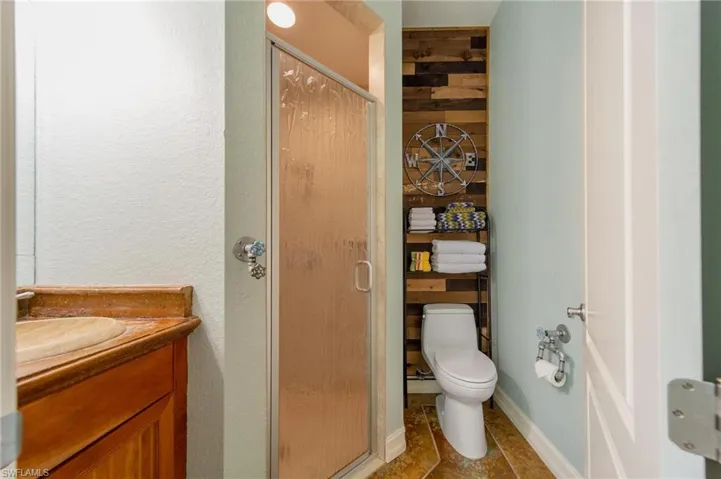 Bathroom featuring vanity, toilet, and walk in shower