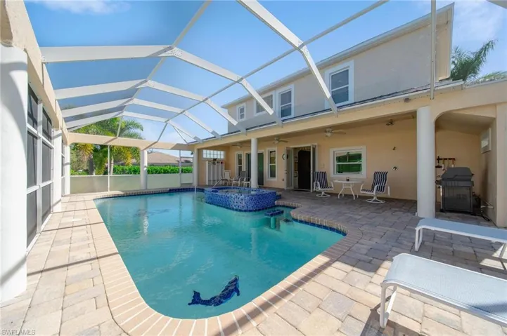 View of pool featuring an in ground hot tub, a patio, glass enclosure, and ceiling fan