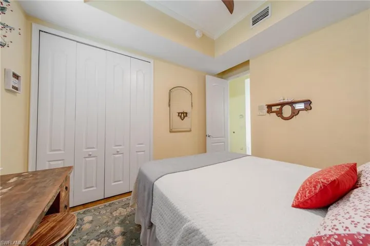 Bedroom with crown molding, a closet, ceiling fan, and hardwood / wood-style floors