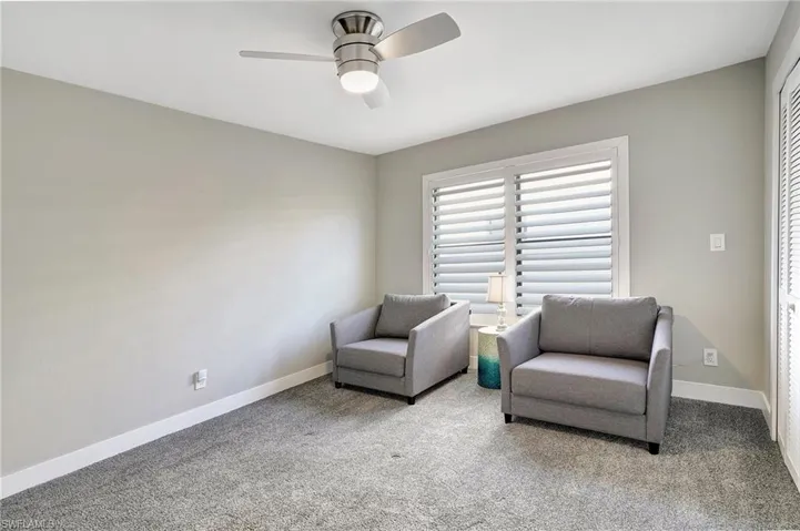 Living area featuring ceiling fan and light carpet