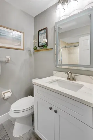 Bathroom with a tile shower, vanity, and toilet