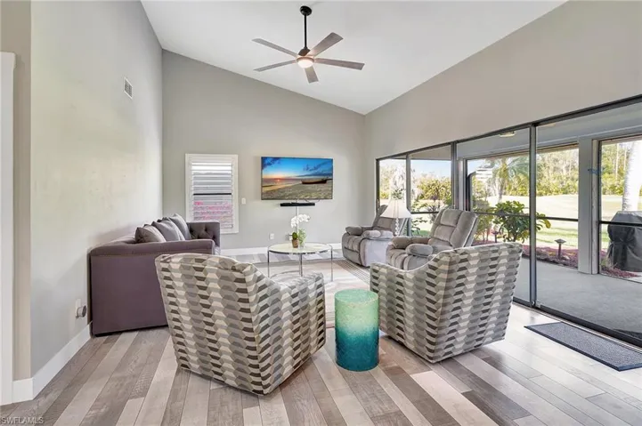 Living room featuring light hardwood / wood-style flooring, high vaulted ceiling, and ceiling fan