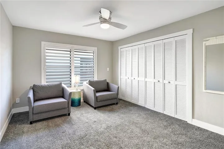 Living area featuring carpet and ceiling fan