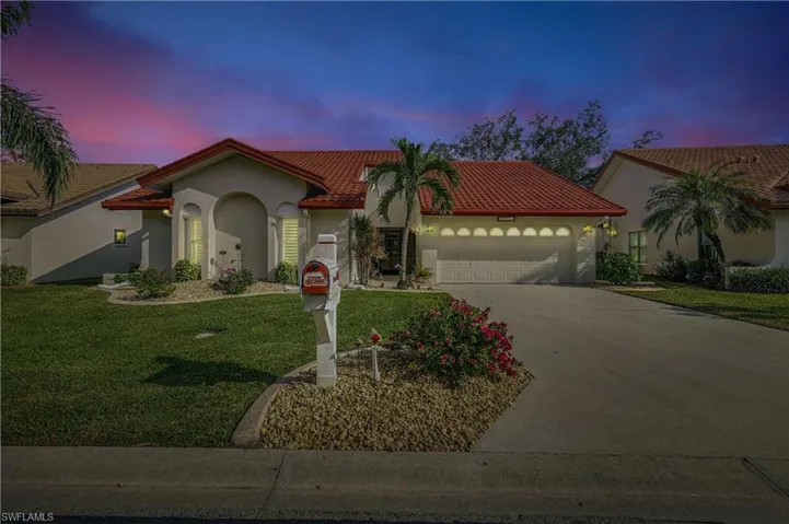 Mediterranean / spanish-style house with a yard and a garage