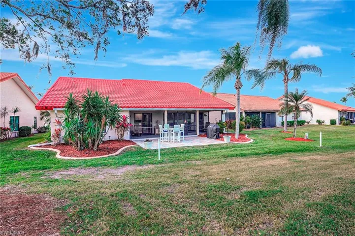 Back of property with a lawn, a sunroom, and a patio