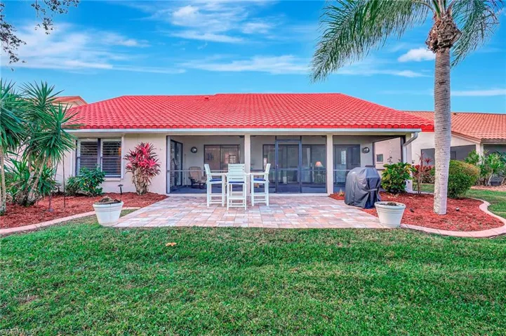 Rear view of house with a yard and a sunroom