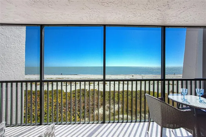 Sunroom / solarium with view of water and beach