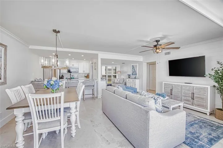 Living area with ceiling fan, crown molding, tile flooring