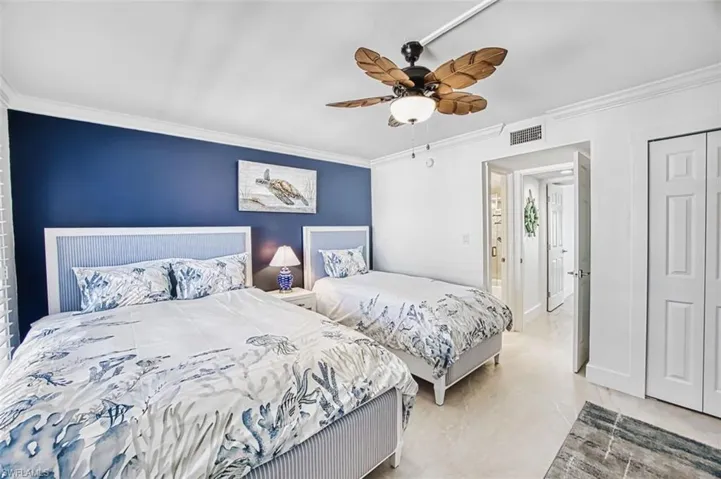 Bedroom with ornamental molding, a ceiling fan, and a closet