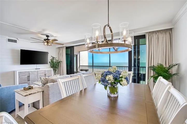 Dining area featuring a ceiling fan, a chandelier, and ornamental molding