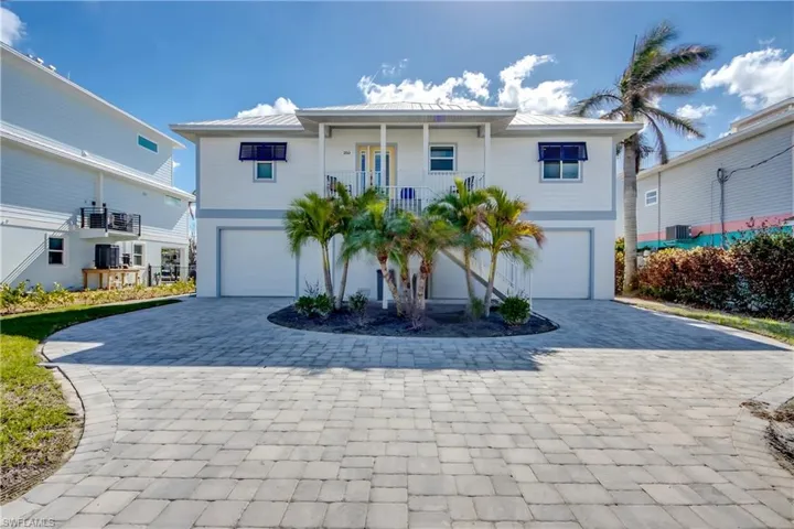 View of front of home with a garage and central air condition unit