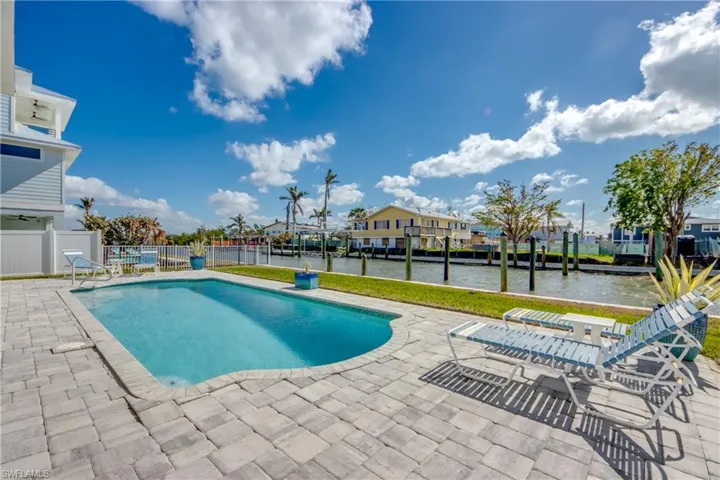View of swimming pool with a patio area and a water view