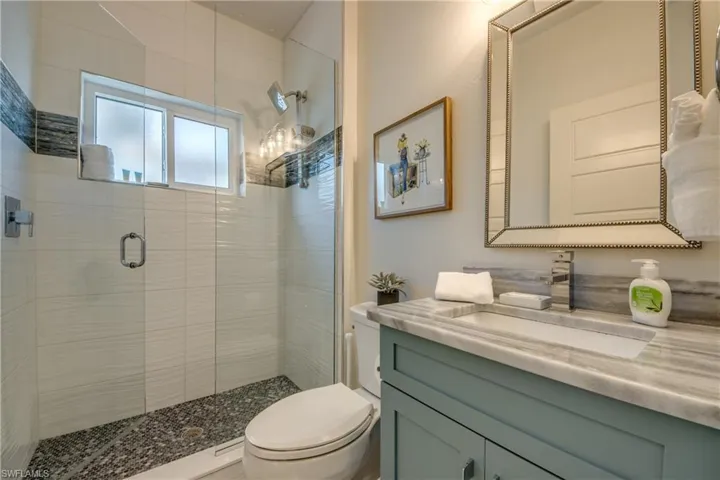Bathroom with vanity, an enclosed shower, and toilet