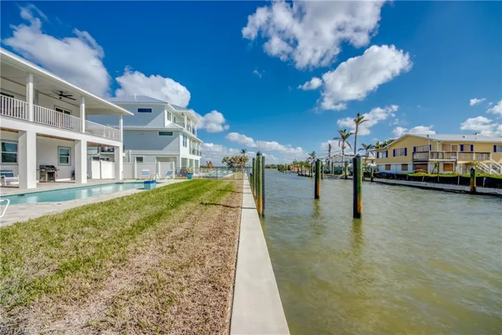 Dock area with a water view and a lawn