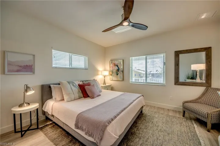 Bedroom with multiple windows, ceiling fan, and light wood-type flooring