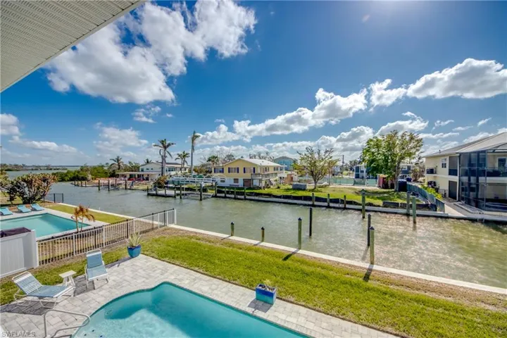 View of swimming pool featuring a yard, a patio area, a boat dock, and a water view