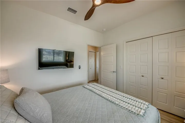 Bedroom with light hardwood / wood-style floors, a closet, and ceiling fan