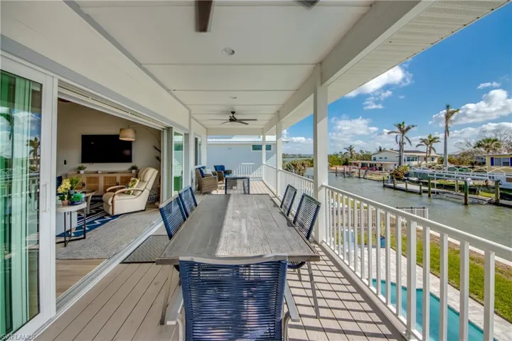 Wooden deck featuring a water view and ceiling fan