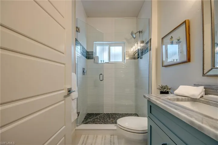 Bathroom with walk in shower, vanity, and toilet