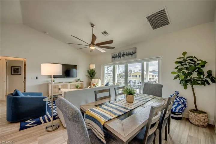 Dining room featuring lofted ceiling, ceiling fan, and light wood-type flooring
