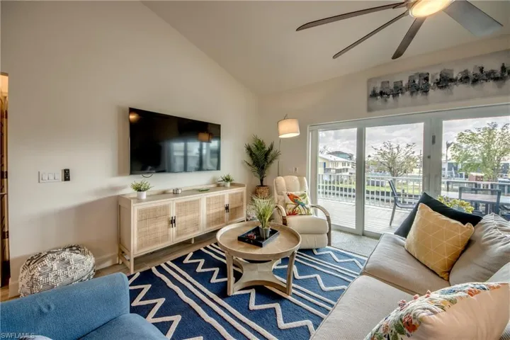 Living room with lofted ceiling, hardwood / wood-style floors, and ceiling fan