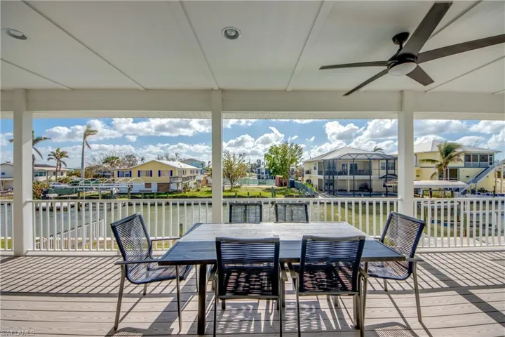 Deck with a water view and ceiling fan
