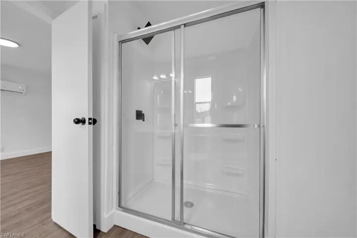 Full standing shower enclosure with sliding glass doors and dark bronze fixtures