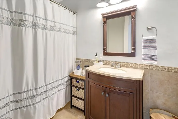 Bathroom featuring tile walls, vanity, and tile patterned floors