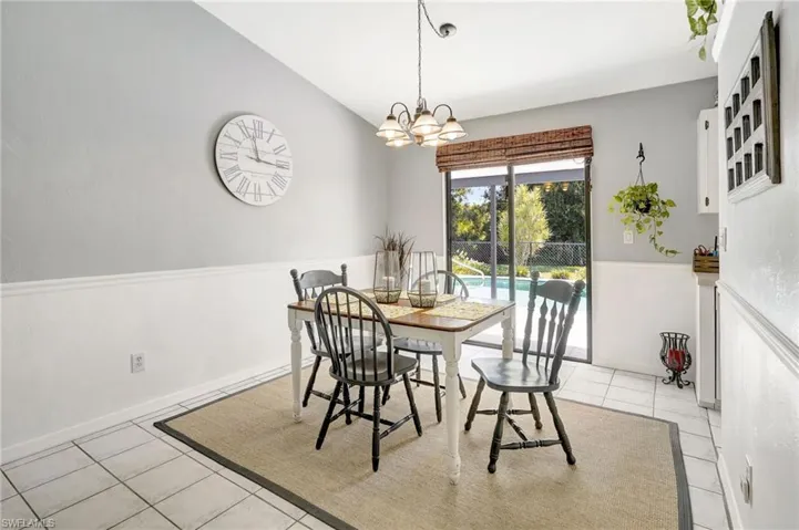 Tiled dining room with vaulted ceiling and a notable chandelier