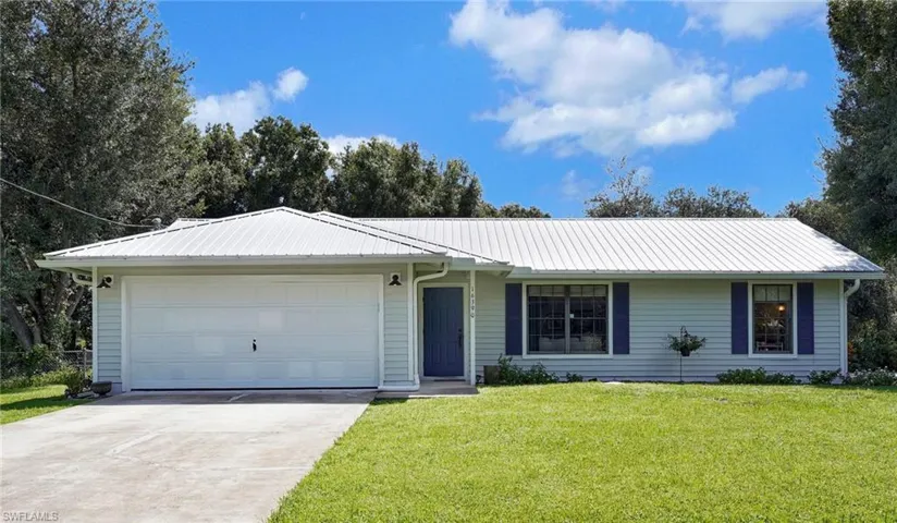 Single story home featuring a garage and a front lawn
