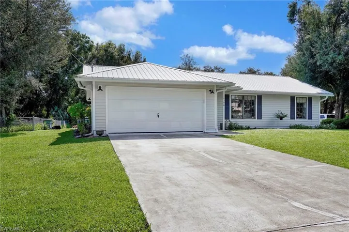 Single story home with a garage and a front yard