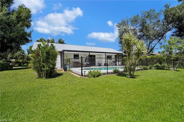 Rear view of property with a lawn