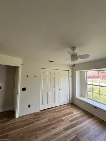 Unfurnished bedroom featuring light wood-style floors, a closet, and ceiling fan