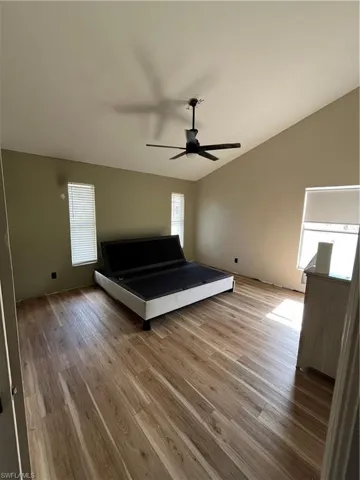 Bedroom with lofted ceiling, light wood-style flooring, and ceiling fan